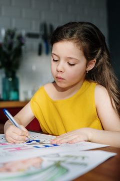 young girl drawing a picture at a table
