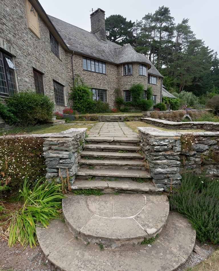 Stone work partially frames steps that lead the eye up to a beautiful property.
